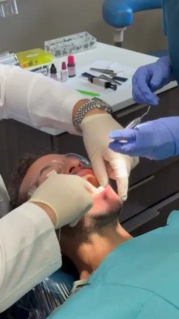 Dentist and dental assistant providing dental treatment to a patient at Florida Smiles Dental