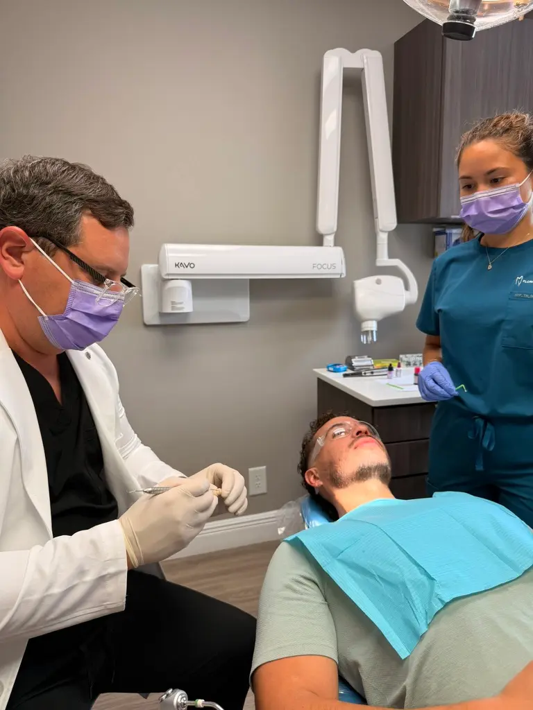 Dentist and dental assistant preparing to provide treatment to a patient at Florida Smiles Dental