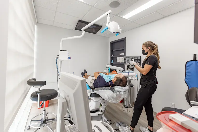 Dental professional preparing a patient for treatment in a Florida Smiles Dental operatory