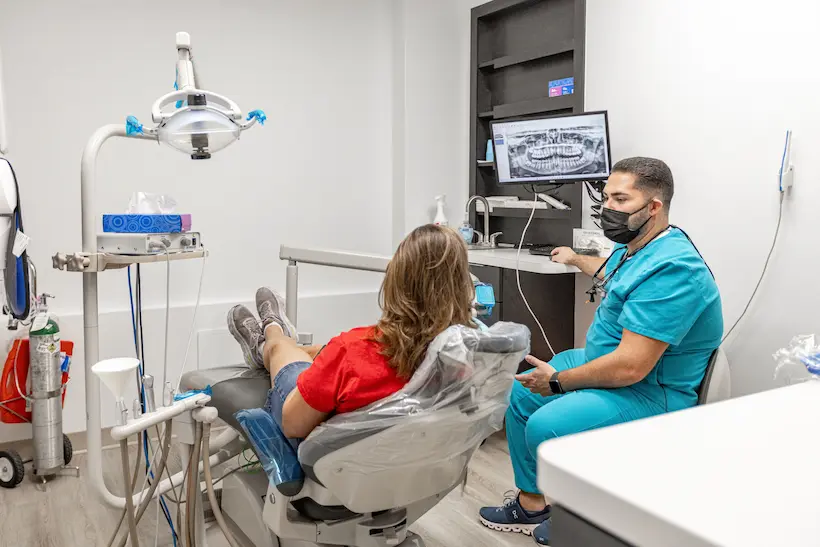Dental professional reviewing a panoramic X-ray with a patient at Florida Smiles Dental