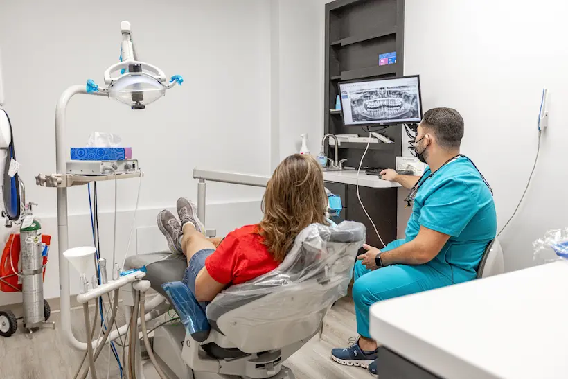 Dental professional reviewing a panoramic X-ray with a patient at Florida Smiles Dental